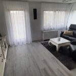 Gemütliches Wohnzimmer mit Sofa und Vitrine in der Ferienwohnung Küssaberg