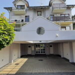 Garagenzufahrt zur Ferienwohnung Küssaberg mit stilvollem Eingangsbereich und grünen Bäumen.