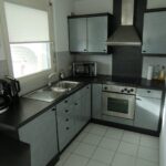 Moderne Küche mit Edelstahlgeräten und grauen Schränken