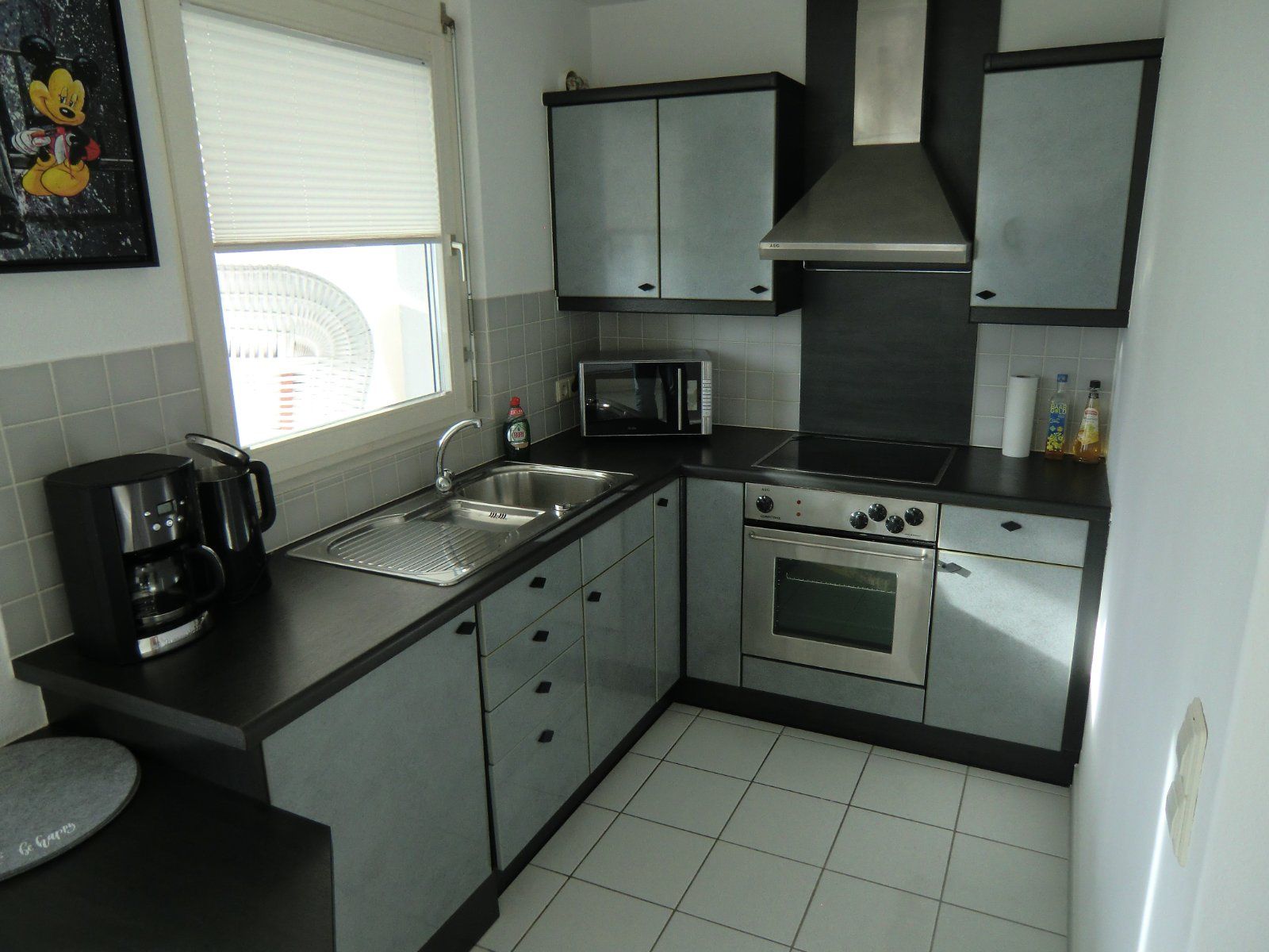 Moderne Küche mit Edelstahlgeräten und grauen Schränken