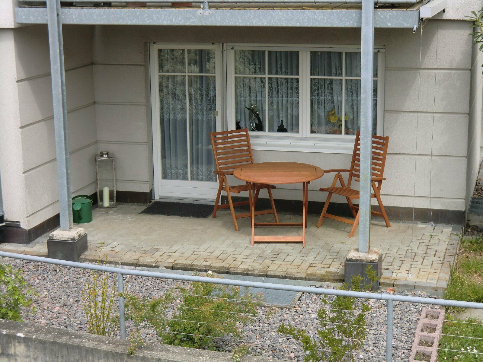Die Terrasse der Ferienwohnung Ahorn mit einem Holztisch und Stühlen, ideal für entspannte Momente im Freien.