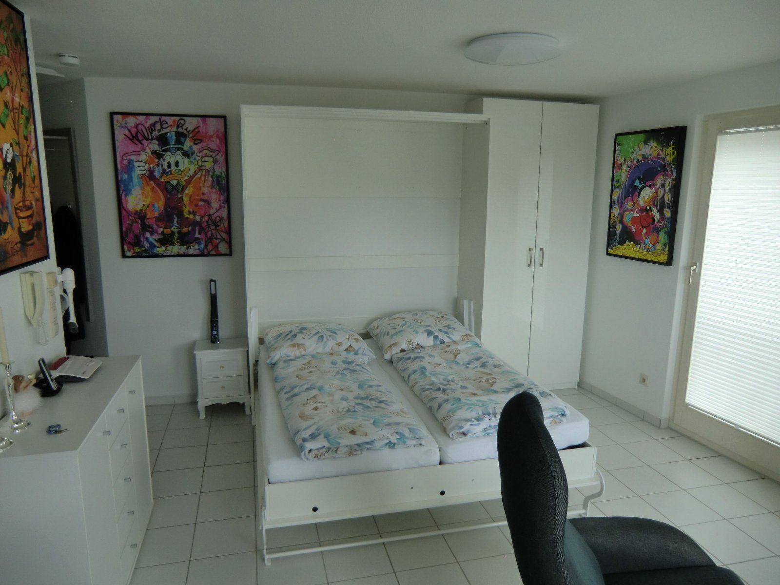 Modern eingerichtetes Zimmer mit Doppelbett und Kunst an den Wänden