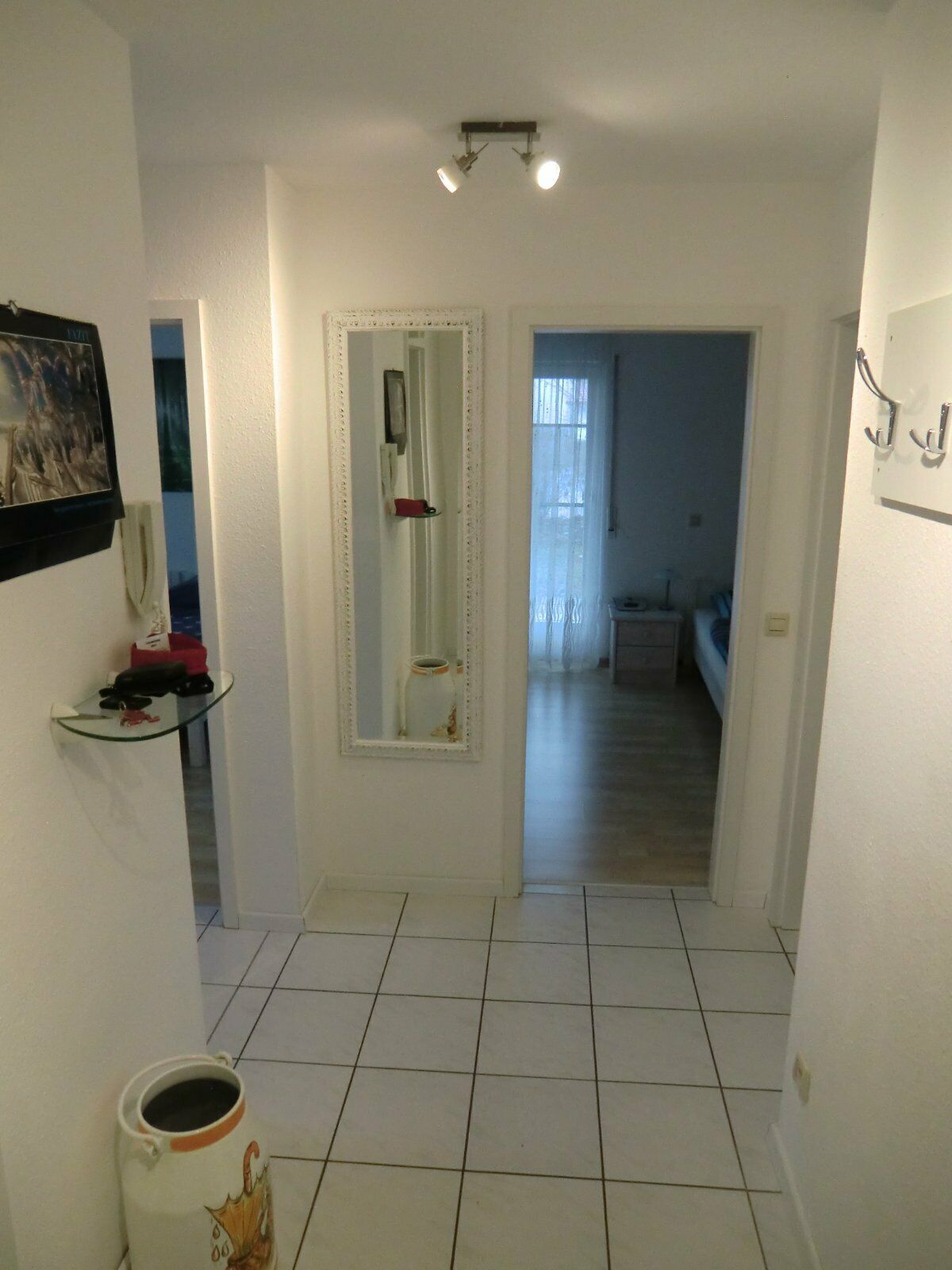 Flur in der Ferienwohnung Ahorn mit einem langen Spiegel, einer Garderobe und einem freundlichen Ambiente. Der Raum führt zu den Schlafzimmern der Wohnung.