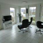 Helles Wohnzimmer mit großen Fenstern und Flussblick