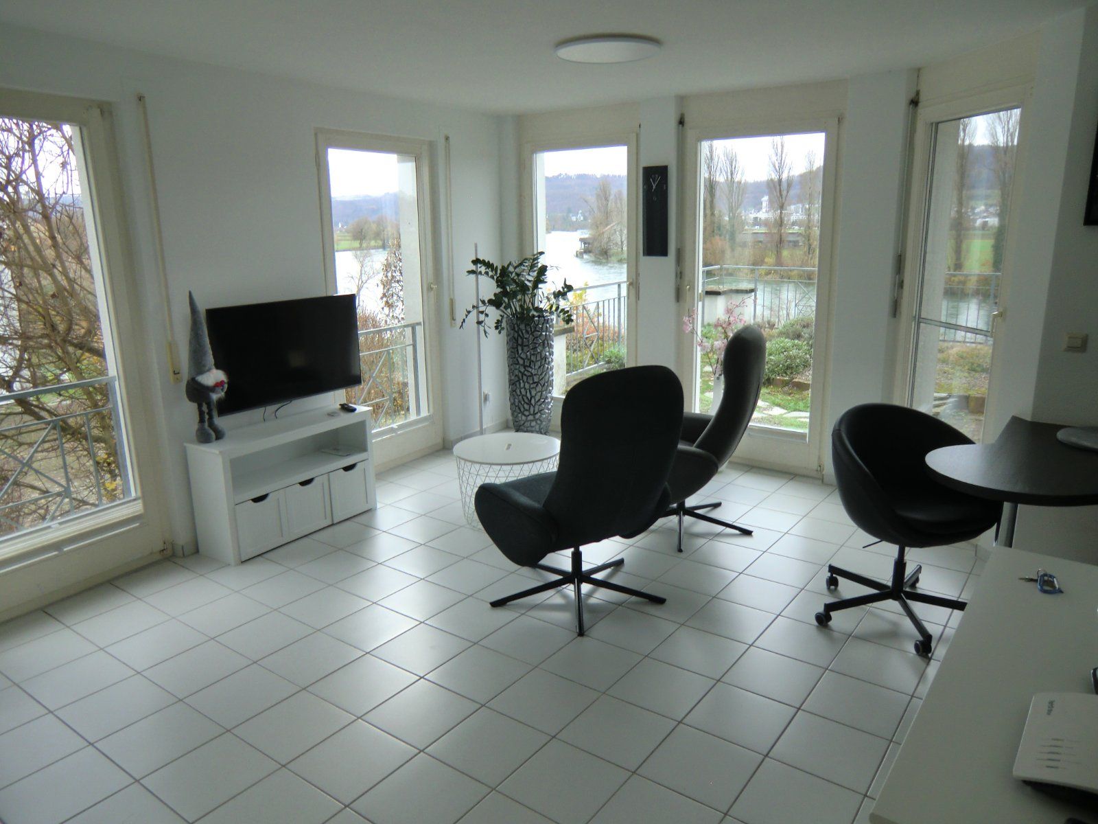 Helles Wohnzimmer mit großen Fenstern und Flussblick