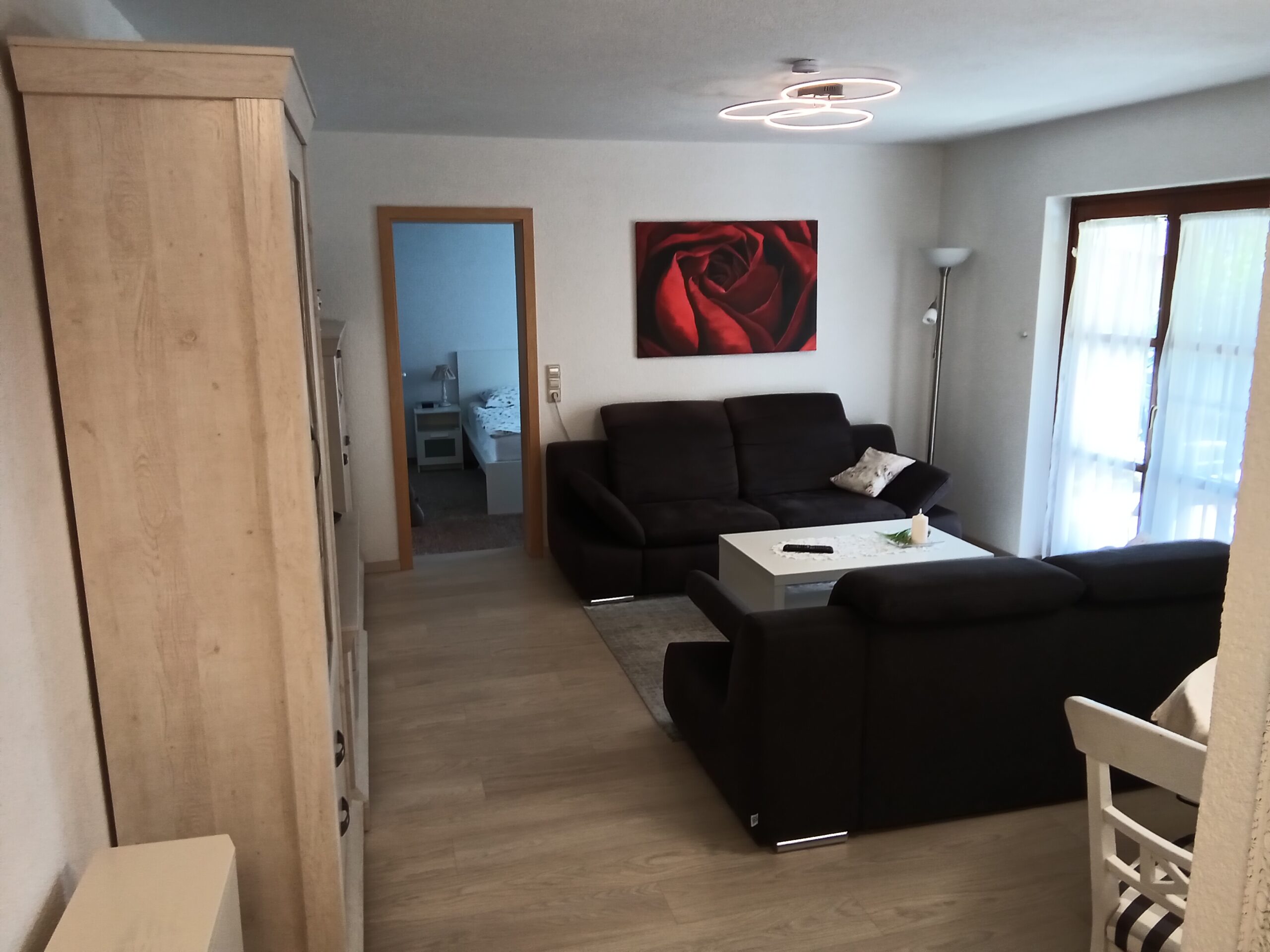 Wohnbereich der Ferienwohnung mit Sofa und Blick ins Schlafzimmer