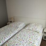 Schlafzimmer mit zwei Einzelbetten und Nachttischen