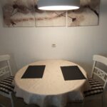 Kleiner Esstisch für zwei Personen mit dekorativen Platzsets und einer gemütlichen Beleuchtung.