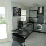 Moderne Küche mit Eckaufbau, Herd, Spüle und Frühstückstheke